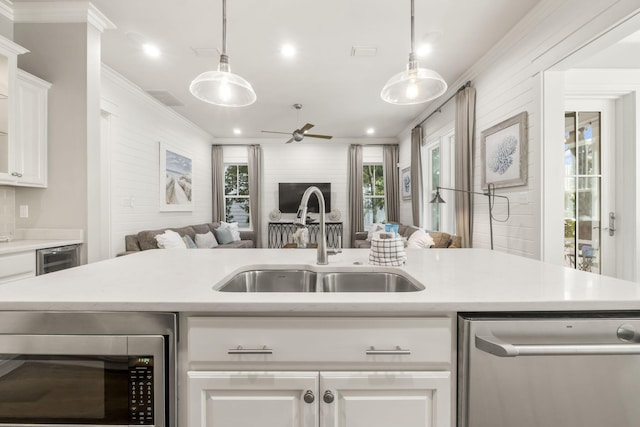 kitchen with white cabinetry, appliances with stainless steel finishes, sink, and decorative light fixtures