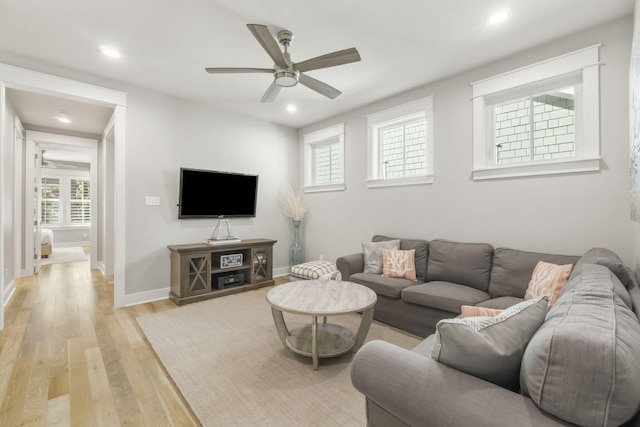 living room featuring light hardwood / wood-style flooring and ceiling fan