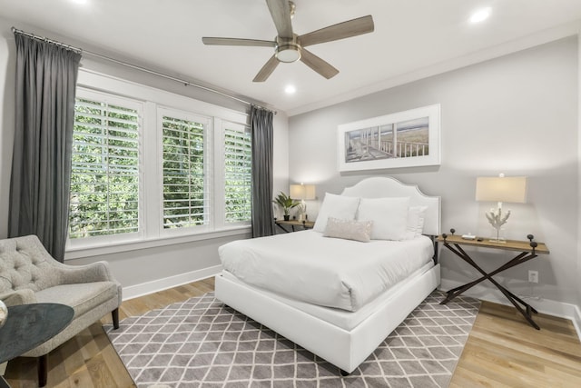 bedroom with hardwood / wood-style flooring, ceiling fan, and ornamental molding