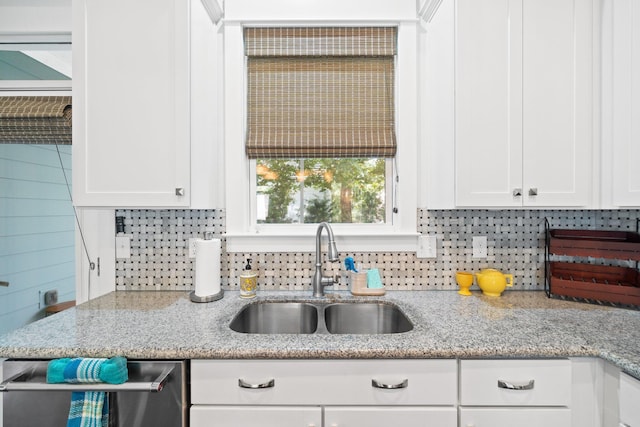 kitchen featuring white cabinetry, light stone countertops, and sink