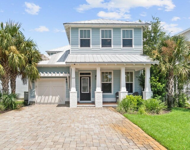 view of front of property featuring a front yard, a garage, and a porch