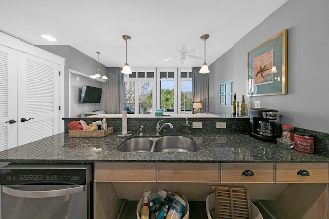 kitchen with dishwasher, dark stone counters, ceiling fan, sink, and decorative light fixtures