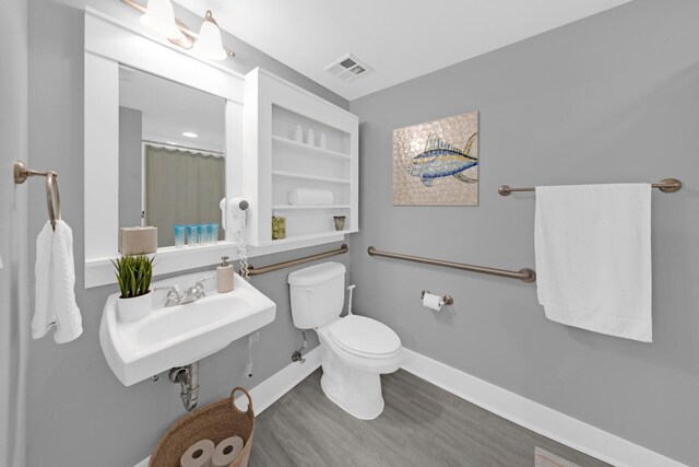 bathroom with hardwood / wood-style floors and toilet