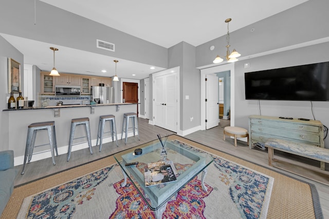 living room with an inviting chandelier and wood-type flooring