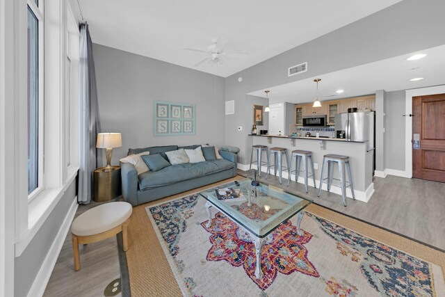 living room with ceiling fan and light wood-type flooring