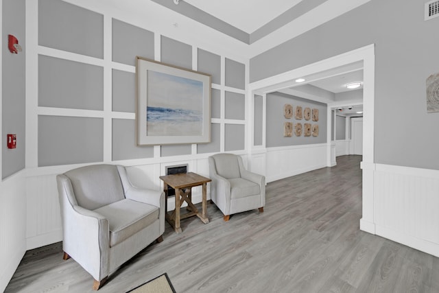 living area featuring wood-type flooring and a raised ceiling