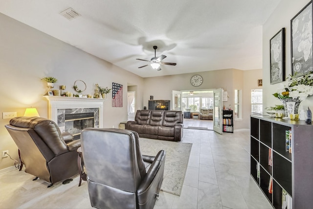 living room with ceiling fan, light tile patterned floors, and a fireplace