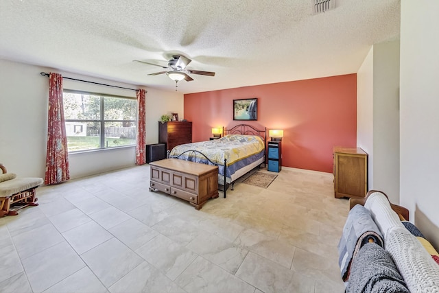 tiled bedroom featuring ceiling fan and a textured ceiling