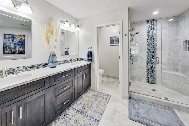 bathroom featuring tile patterned flooring, a textured ceiling, toilet, dual vanity, and a shower with door