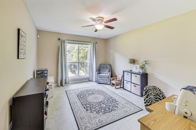 living area featuring ceiling fan, a textured ceiling, and light tile patterned floors