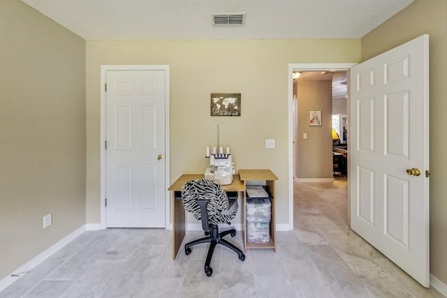 office with light tile patterned floors and a textured ceiling