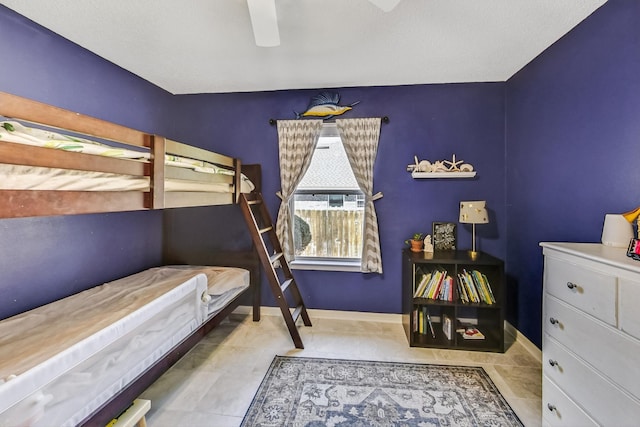 tiled bedroom featuring ceiling fan