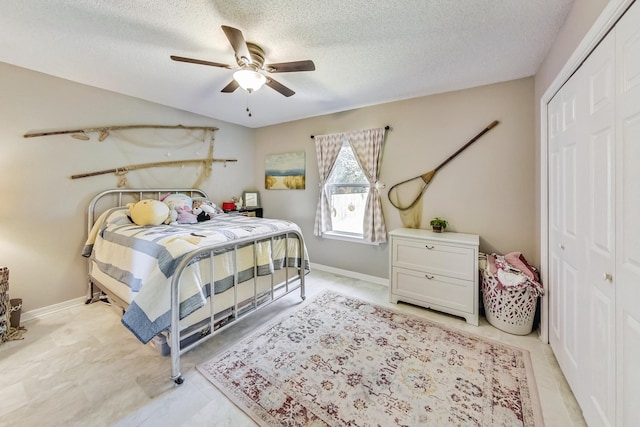 tiled bedroom with a textured ceiling, a closet, and ceiling fan