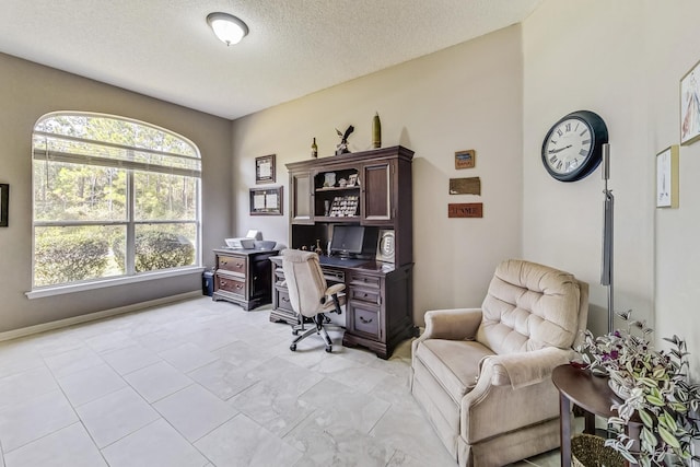 office area featuring a wealth of natural light, light tile patterned flooring, and a textured ceiling