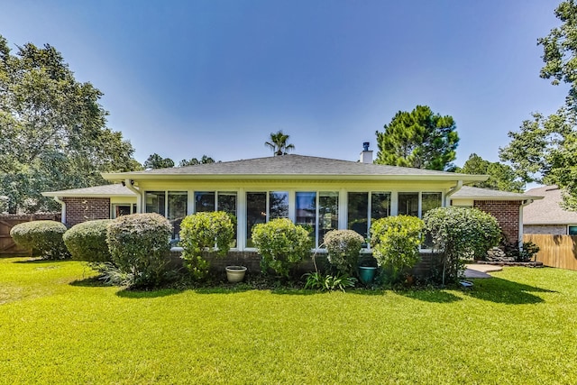 rear view of house featuring a yard