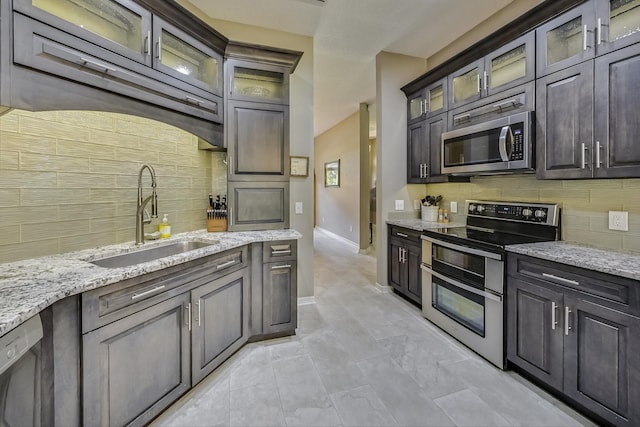 kitchen with sink, tasteful backsplash, light tile patterned floors, and stainless steel appliances