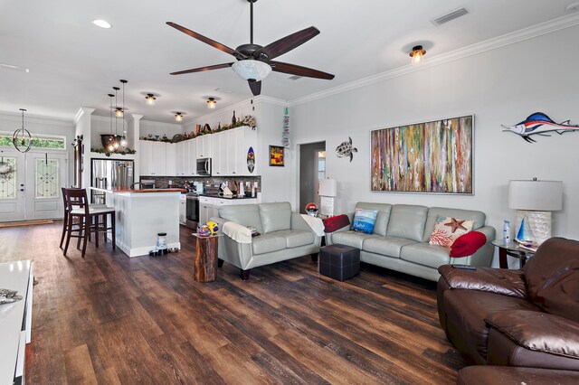 living room with crown molding, ceiling fan with notable chandelier, and dark hardwood / wood-style flooring