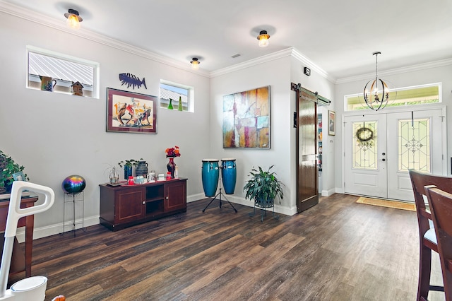 foyer entrance with ornamental molding, an inviting chandelier, dark wood-type flooring, and a barn door