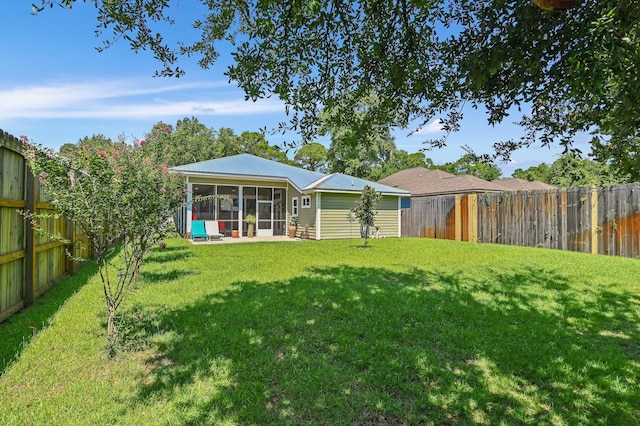 back of house featuring a yard, a sunroom, and a patio area