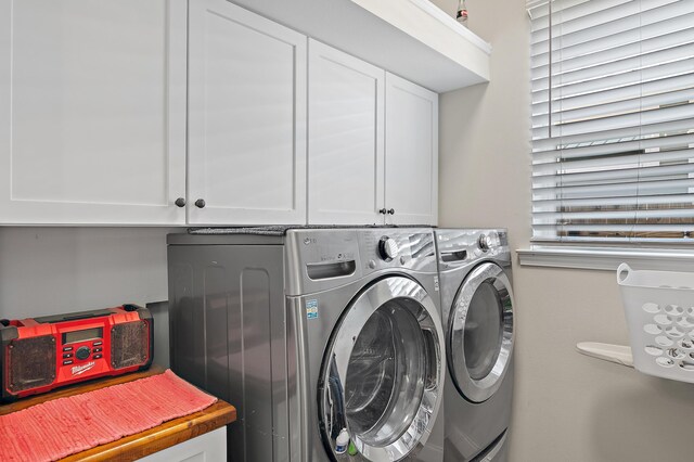 laundry area featuring independent washer and dryer and cabinets