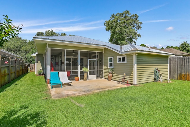 back of house featuring a patio area, a yard, and a sunroom