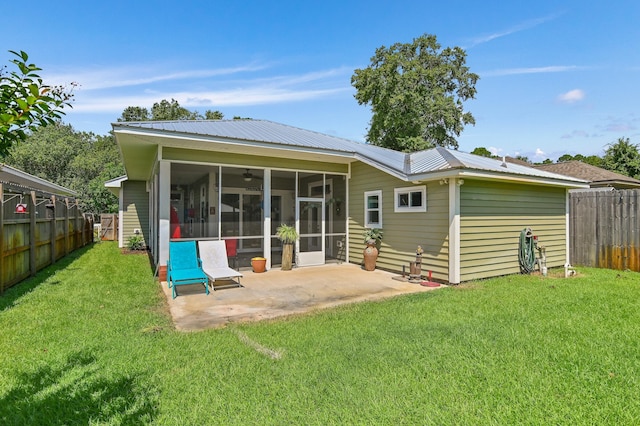 rear view of property featuring a yard, a patio area, and a sunroom