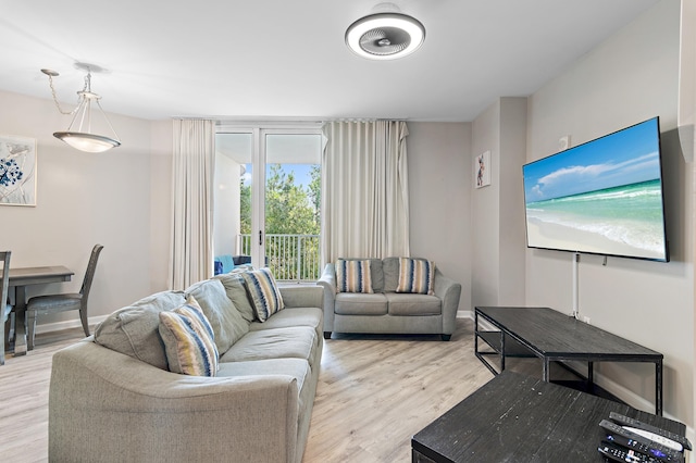 living area featuring light wood-style flooring and baseboards