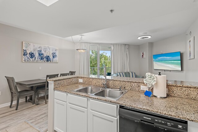 kitchen with black dishwasher, sink, light wood-type flooring, light stone counters, and white cabinetry