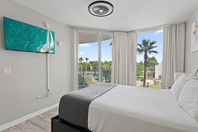 bedroom featuring light wood-style floors, access to outside, multiple windows, and baseboards