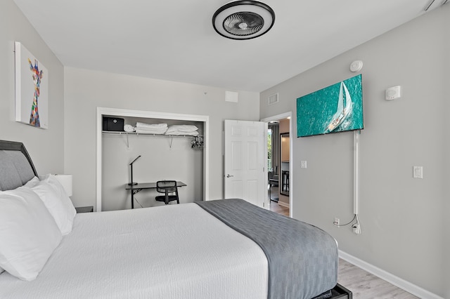 bedroom with a closet, visible vents, baseboards, and light wood finished floors