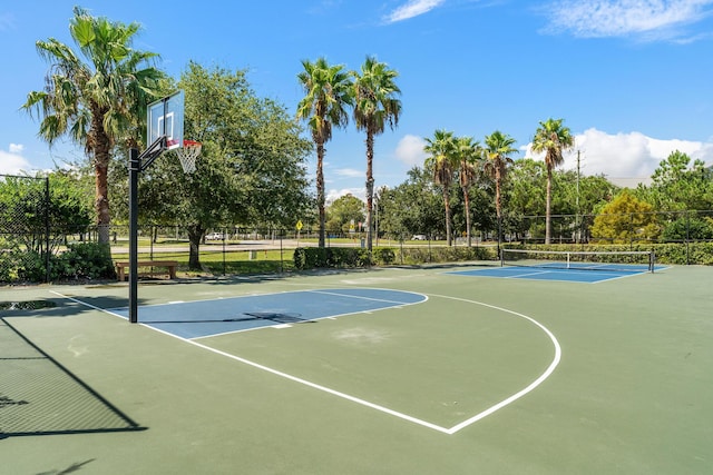 view of basketball court with a tennis court, community basketball court, and fence