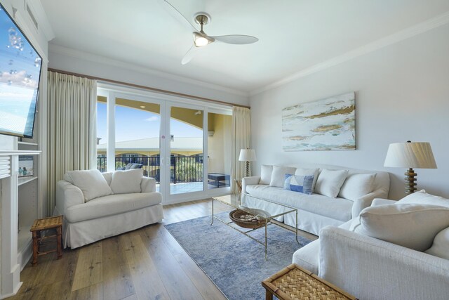 living room with ceiling fan, ornamental molding, and hardwood / wood-style flooring