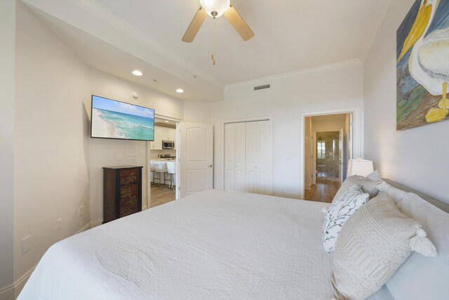 bedroom featuring crown molding, ensuite bathroom, a closet, ceiling fan, and wood-type flooring