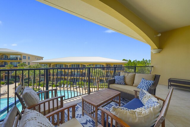 balcony with an outdoor hangout area and a community pool