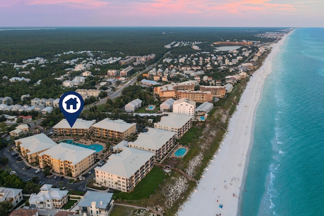 aerial view at dusk featuring a beach view and a water view