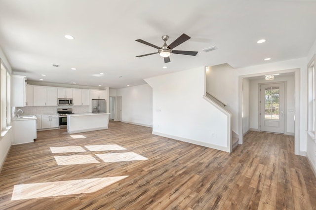 76 Azalea Dr, Freeport, FL 32439 - unfurnished living room with recessed lighting, light wood-style floors, ceiling fan, baseboards, and a sink