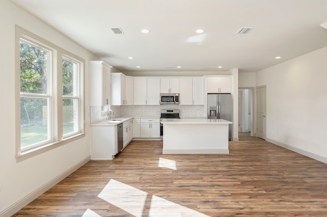 76 Azalea Dr, Freeport, FL 32439 - kitchen featuring stainless steel appliances, a sink, tasteful backsplash, light wood-style floors, and a kitchen island