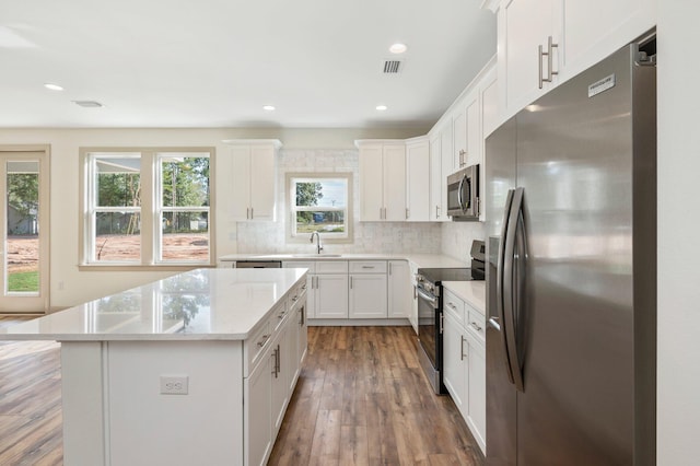 76 Azalea Dr, Freeport, FL 32439 - kitchen featuring stainless steel appliances, a sink, a kitchen island, hardwood / wood-style flooring, and tasteful backsplash
