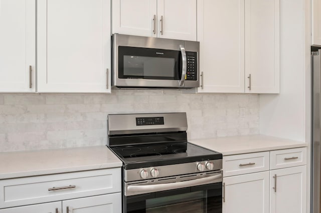 76 Azalea Dr, Freeport, FL 32439 - kitchen with stainless steel appliances, white cabinets, and tasteful backsplash