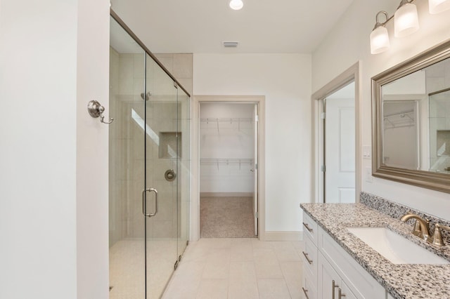 76 Azalea Dr, Freeport, FL 32439 - full bath with a stall shower, a spacious closet, vanity, baseboards, and tile patterned flooring