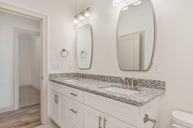 76 Azalea Dr, Freeport, FL 32439 - full bath featuring double vanity, wood finished floors, toilet, and baseboards
