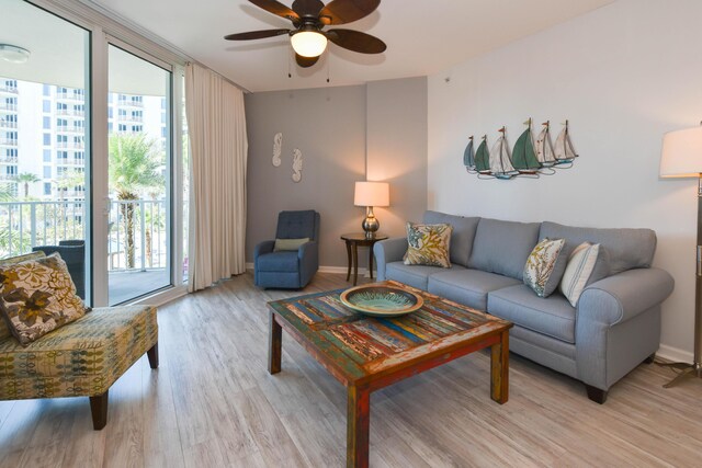 living room with ceiling fan, floor to ceiling windows, and light hardwood / wood-style floors