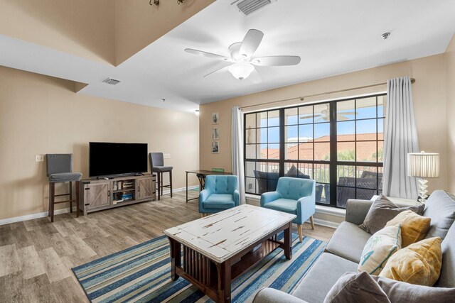 living room with ceiling fan and light hardwood / wood-style floors