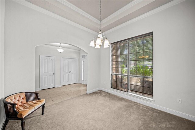 interior space featuring light tile patterned floors, crown molding, an inviting chandelier, and a raised ceiling