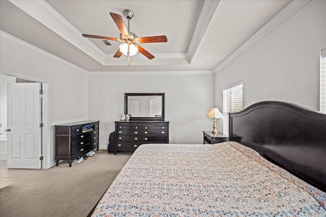 bedroom featuring a textured ceiling, ceiling fan, ornamental molding, a tray ceiling, and light colored carpet