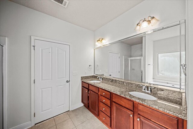 bathroom featuring tile patterned floors, double sink vanity, and walk in shower