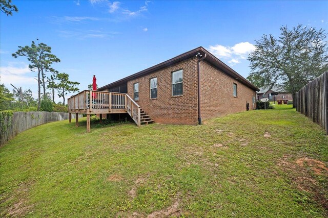 rear view of property with a lawn and a deck