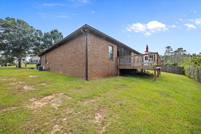 rear view of house featuring central AC, a lawn, and a wooden deck