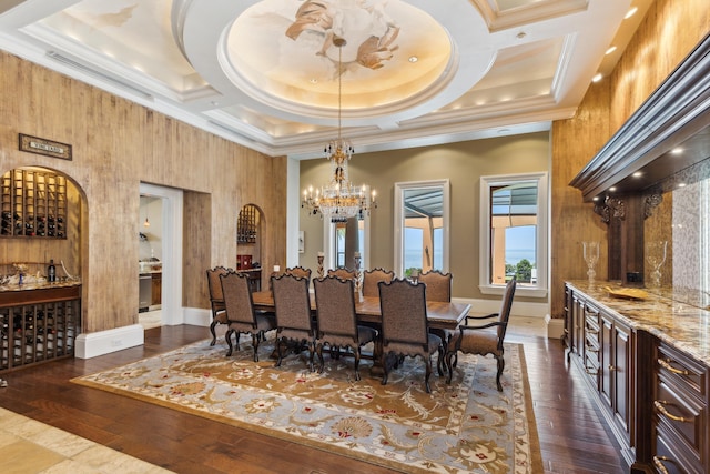 dining area featuring a bar, baseboards, a notable chandelier, and dark wood-type flooring