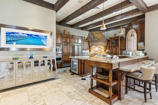 kitchen featuring light stone counters, open shelves, a kitchen breakfast bar, custom exhaust hood, and stone tile flooring